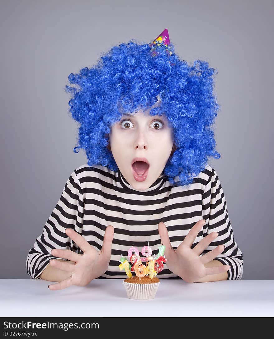 Funny blue-hair girl with cake. Studio shot.