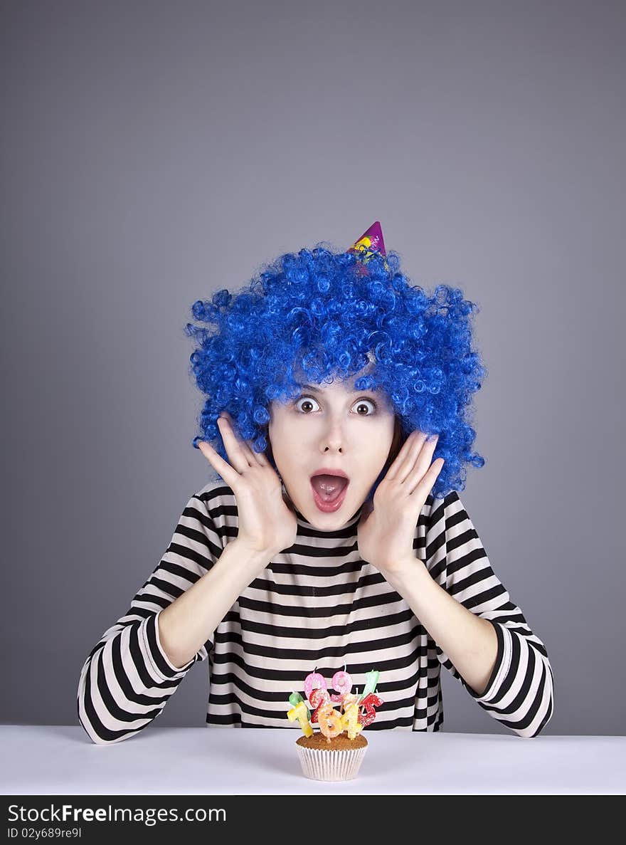 Funny blue-hair girl with cake. Studio shot.