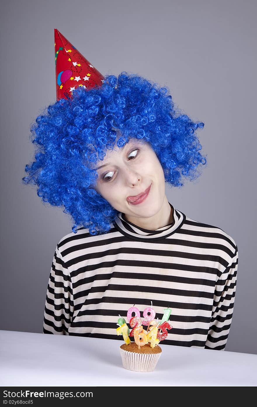 Funny blue-hair girl with cake. Studio shot.