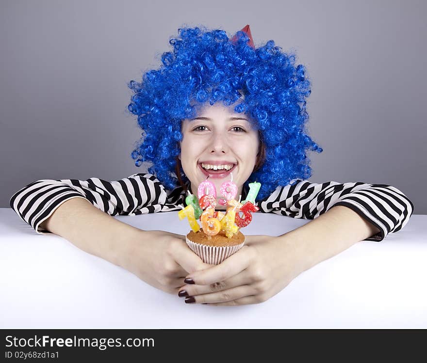 Funny blue-hair girl with cake. Studio shot.