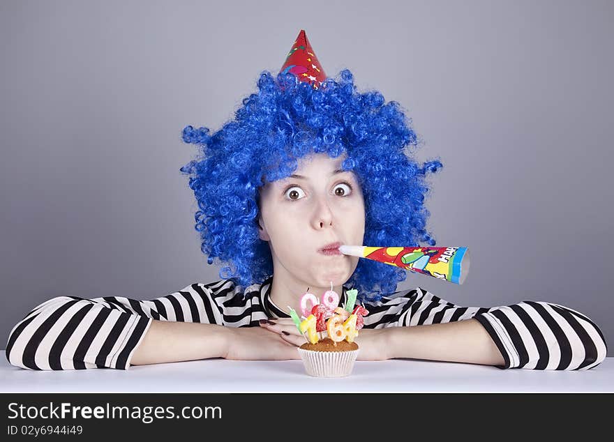 Funny blue-hair girl with cake. Studio shot.