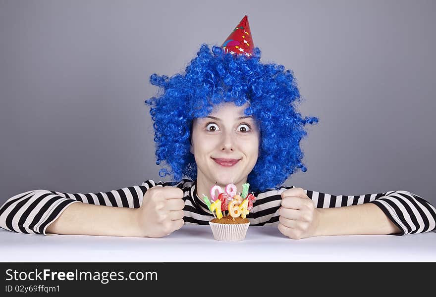 Funny blue-hair girl with cake. Studio shot.