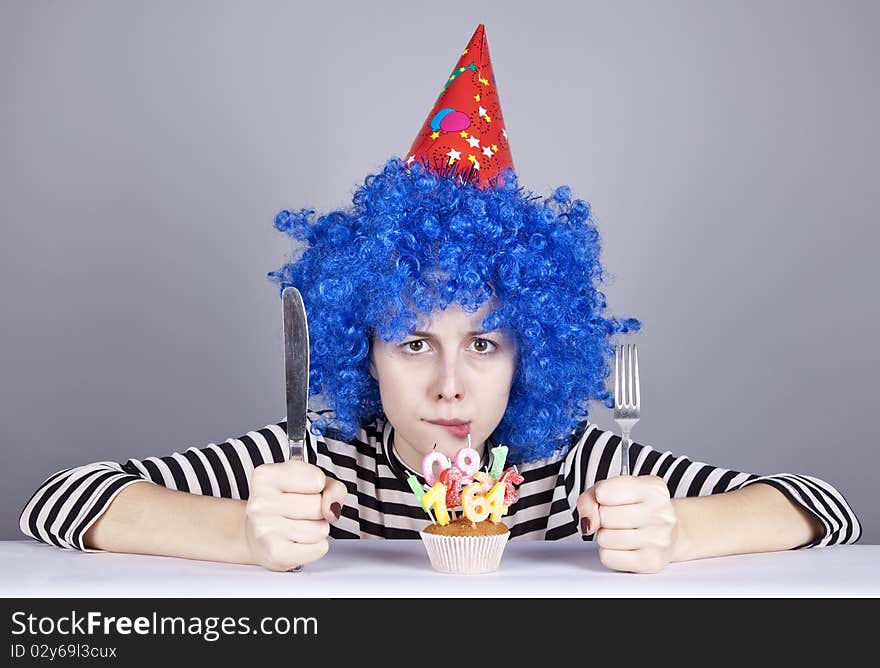 Funny blue-hair girl with cake. Studio shot.