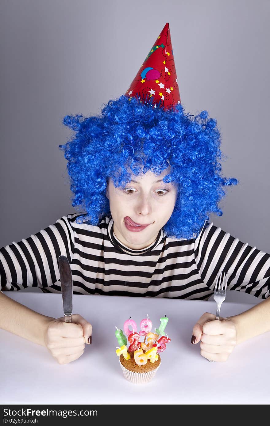 Funny blue-hair girl with cake. Studio shot.