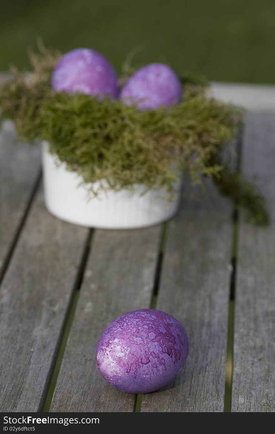 Easter eggs in purple lying on the table outdoor