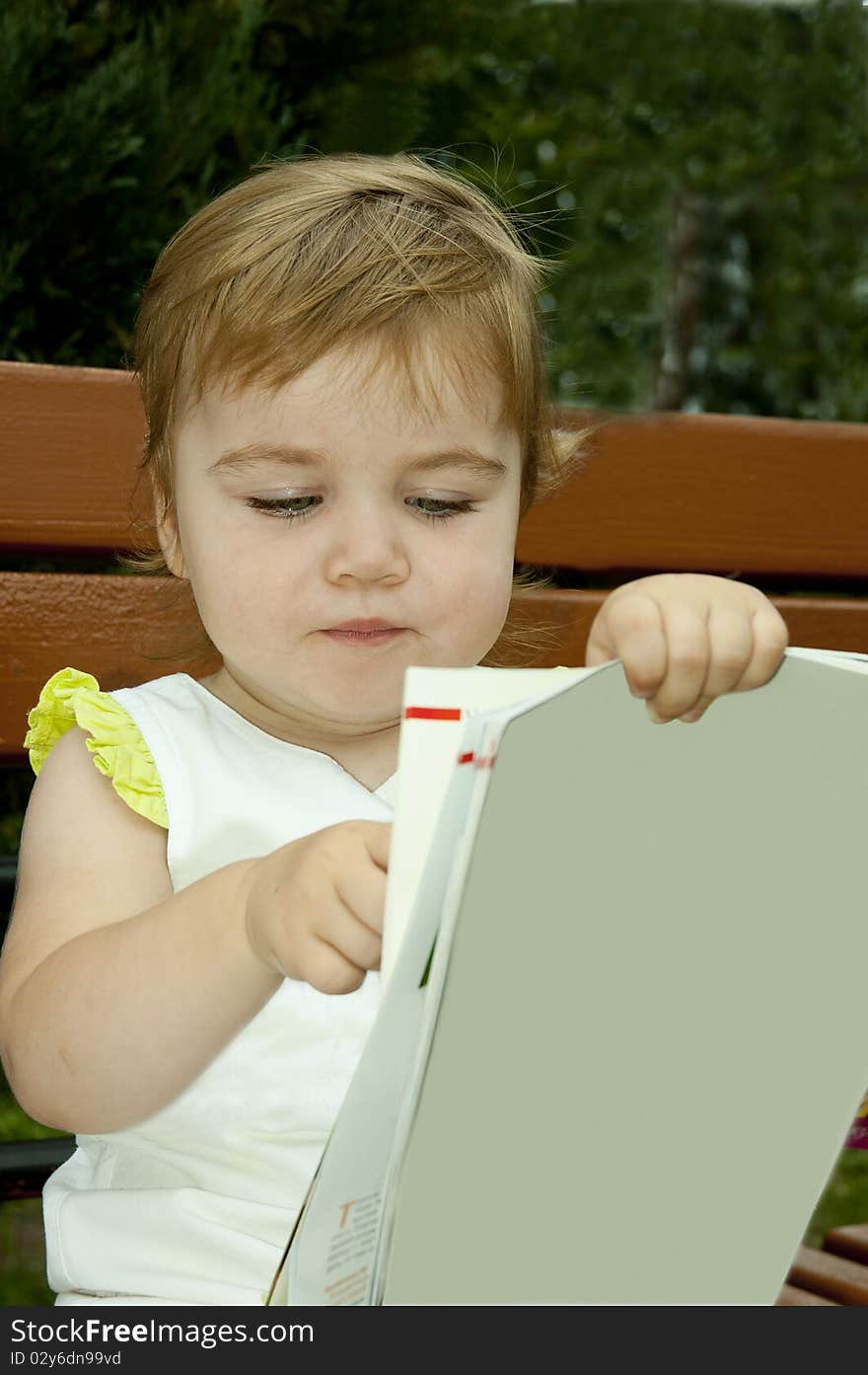 Small child considers the opened book. Keeps the book in a hands. Small child considers the opened book. Keeps the book in a hands.