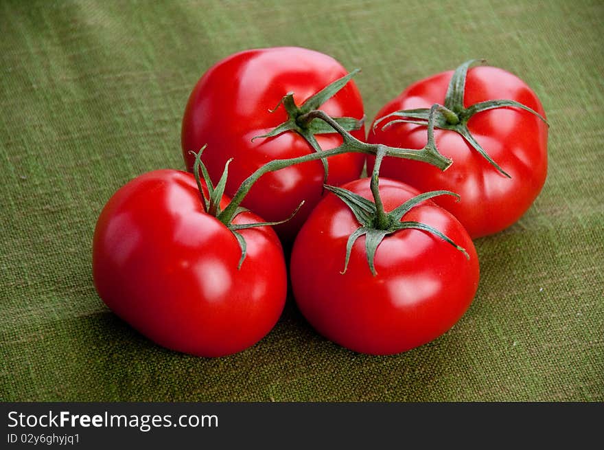 Four tomatoes  on a green napkin