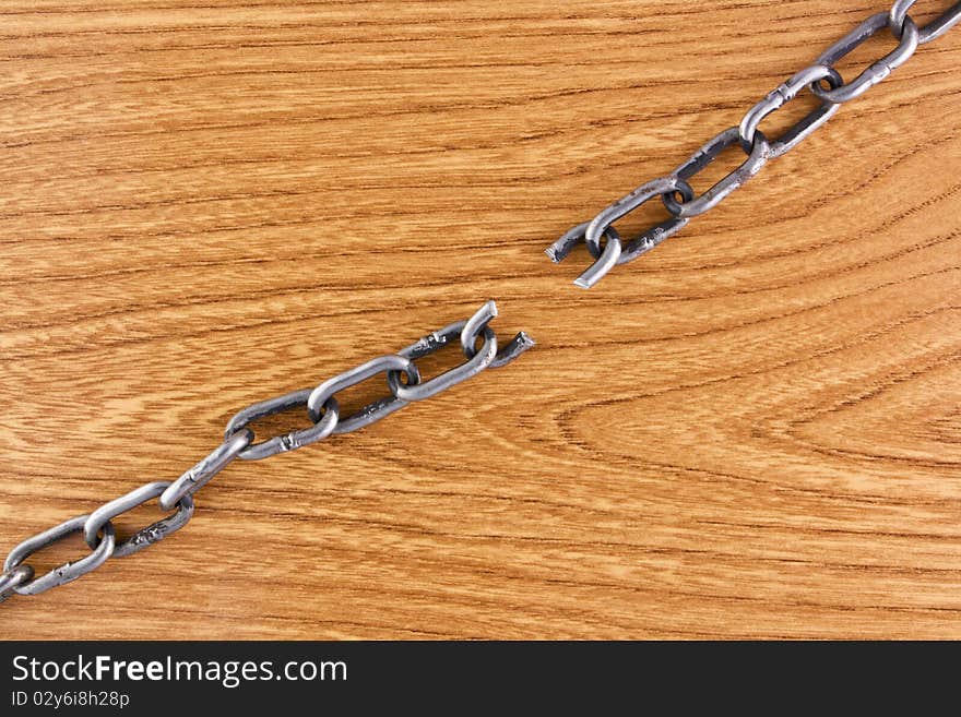 Broken chain over wood texture background