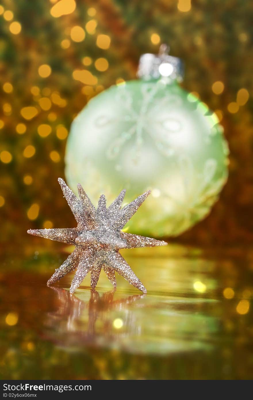 Christmas border of a 3d glitter Christmas star with a light green ornament and lights in the background. Christmas border of a 3d glitter Christmas star with a light green ornament and lights in the background.