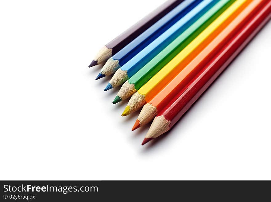 Colored pencils arranged in rainbow spectrum order isolated on white background