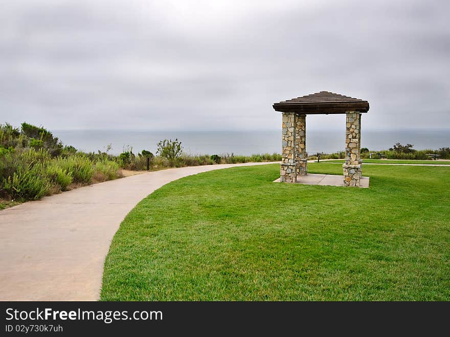 Stone Pillared Gazebo in Grass Near Curvature of Walkway