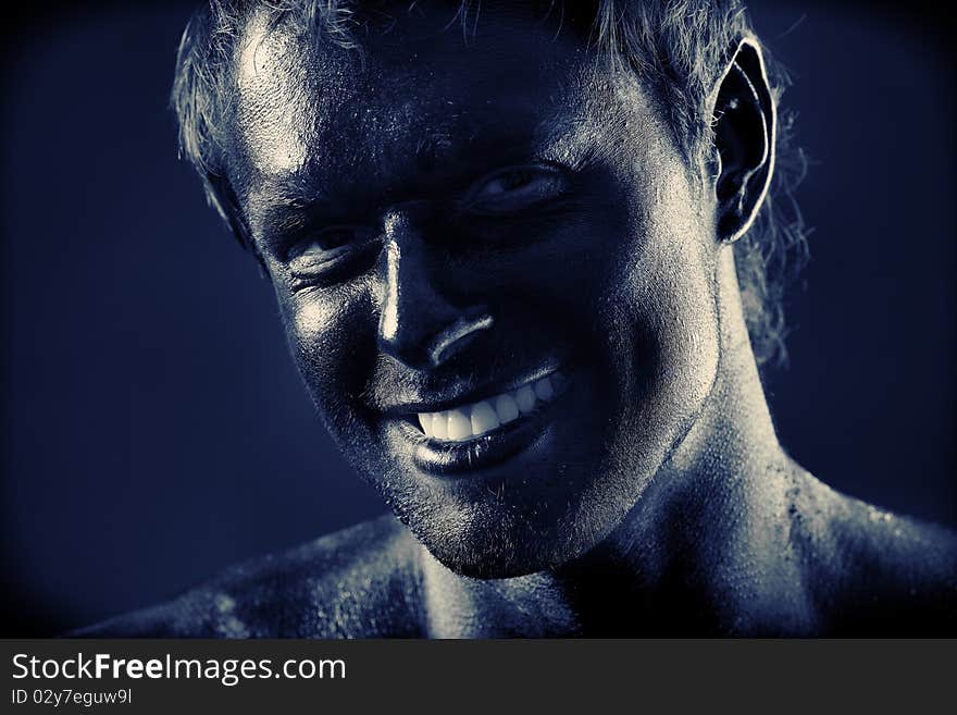 Portrait of expressive man painted with black color. Body painting project. Portrait of expressive man painted with black color. Body painting project.