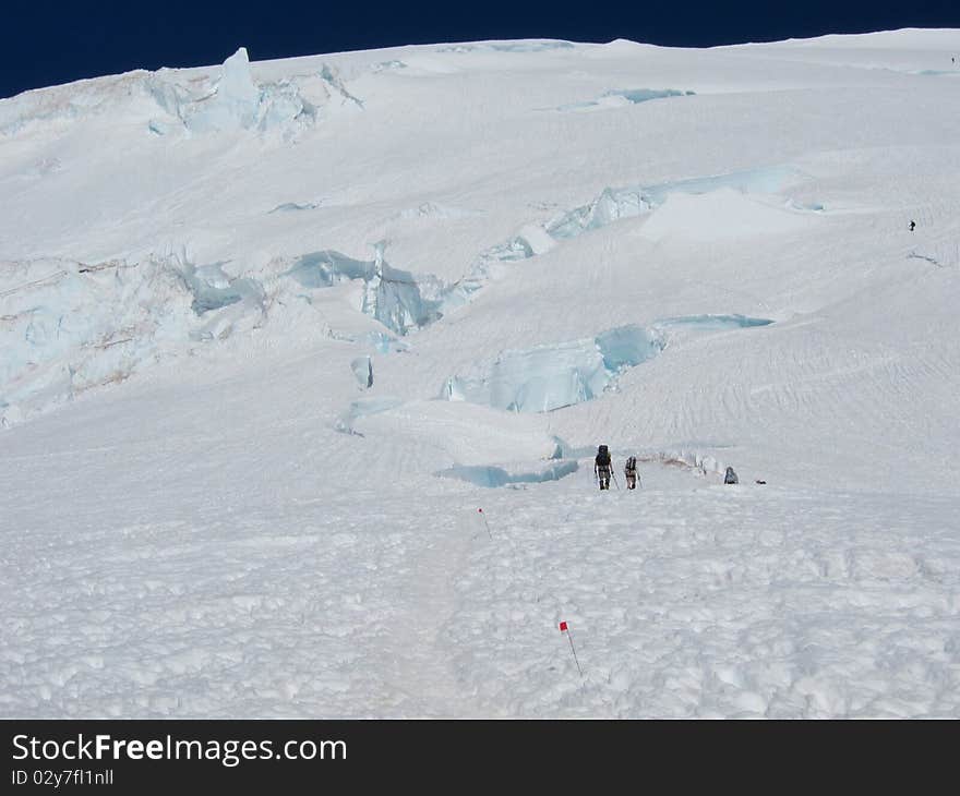 Climbers making their way toward the summit of Mount Rainier. Disappointment Cleaver route, above the cleaver at 12,300 ft. Climbers making their way toward the summit of Mount Rainier. Disappointment Cleaver route, above the cleaver at 12,300 ft.