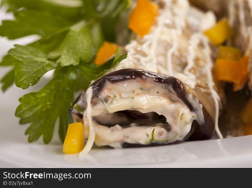 Baked Eggplant rolls stuffed Tomato and Dressed with Parsley. Over white background