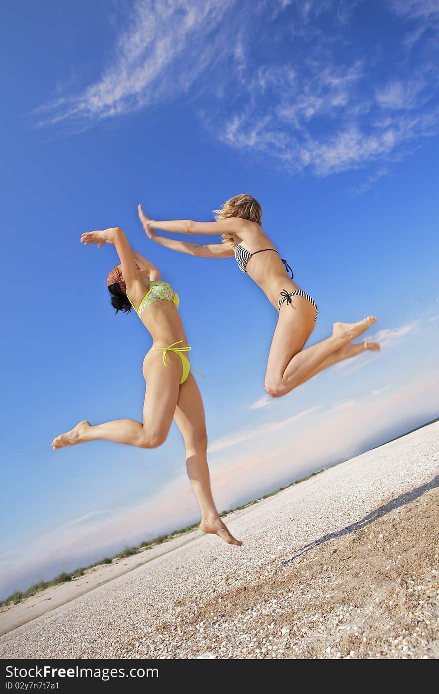 Girls Jumping On A Beach