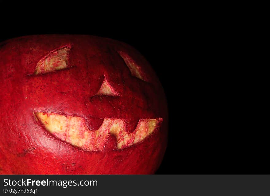 Halloween face cut out on fruit. Isolated on black. Halloween face cut out on fruit. Isolated on black