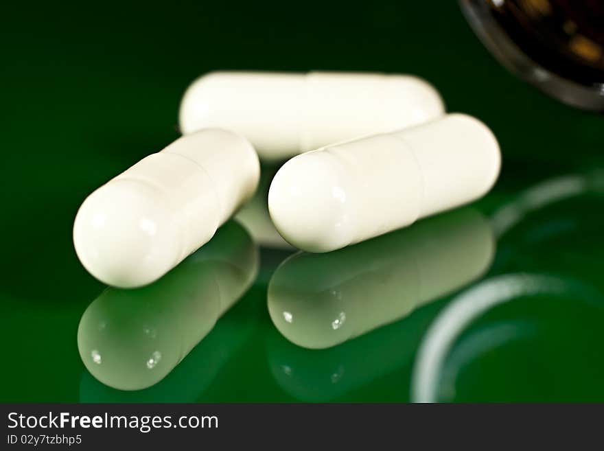 On a green background in the form of capsules open. On a green background in the form of capsules open.