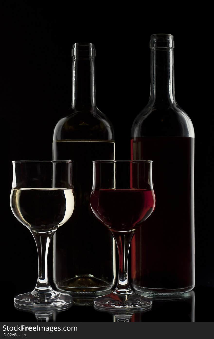 Red and white wine in two glasses and two bottles