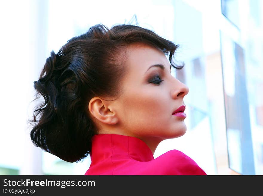 Young and attractive lady in black and pink dress at abstract glass background. Young and attractive lady in black and pink dress at abstract glass background