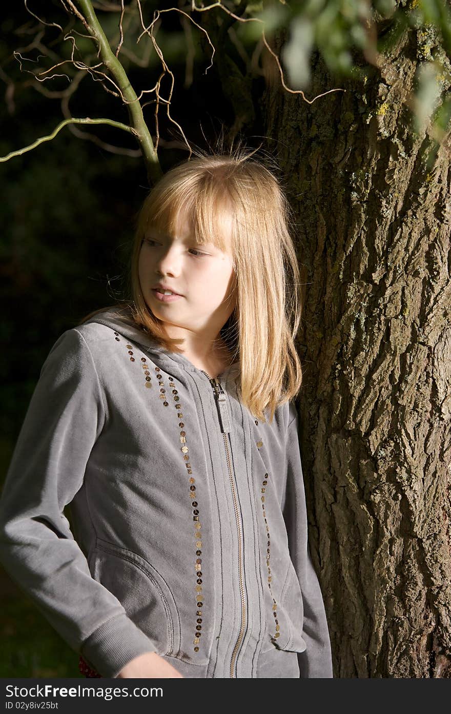 Young Girl Leaning On A Tree