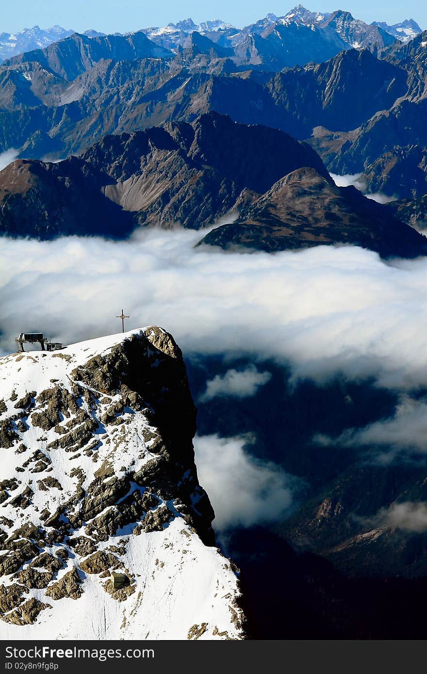 Cross of Zugspitze surrounded by a lot of mountains