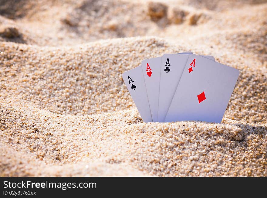 The four Aces dispayed in the sand on a beach. The four Aces dispayed in the sand on a beach.