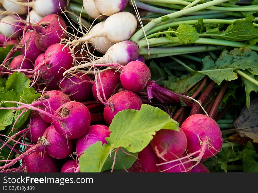 Crimson and white turnips on display at a farmer's market