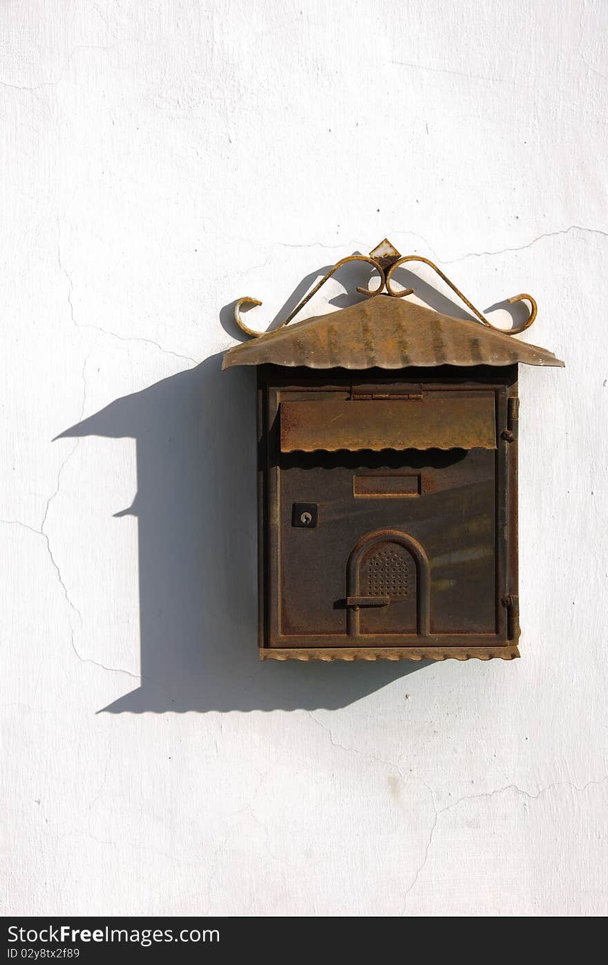 Old rusty mailbox on a white wall