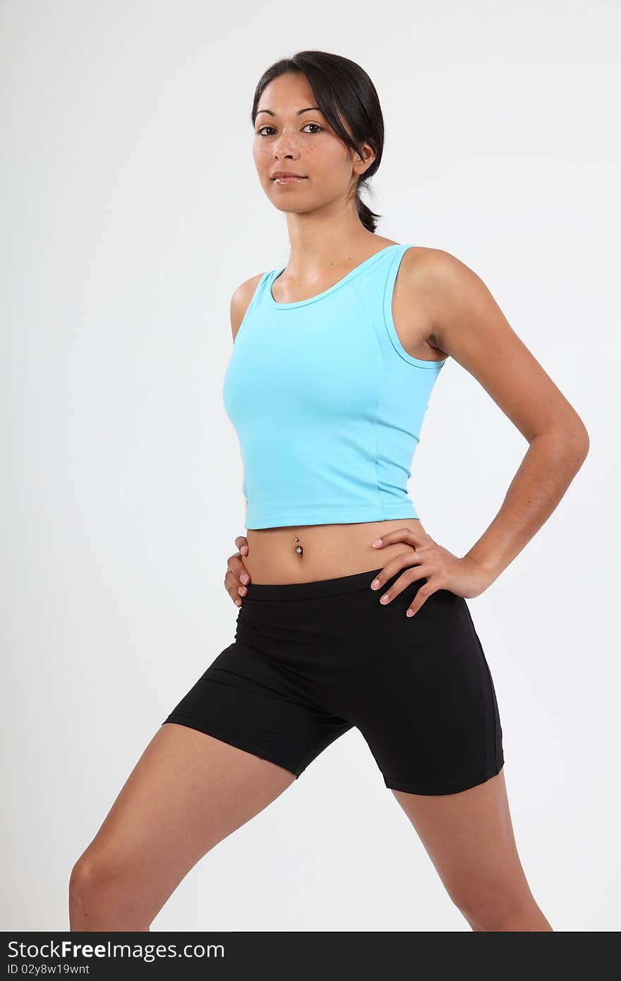 Young athletic woman warming up by stretching before exercise routine. Calm non smiling gaze to camera. Studio shot - Canon 5D MKII. Young athletic woman warming up by stretching before exercise routine. Calm non smiling gaze to camera. Studio shot - Canon 5D MKII