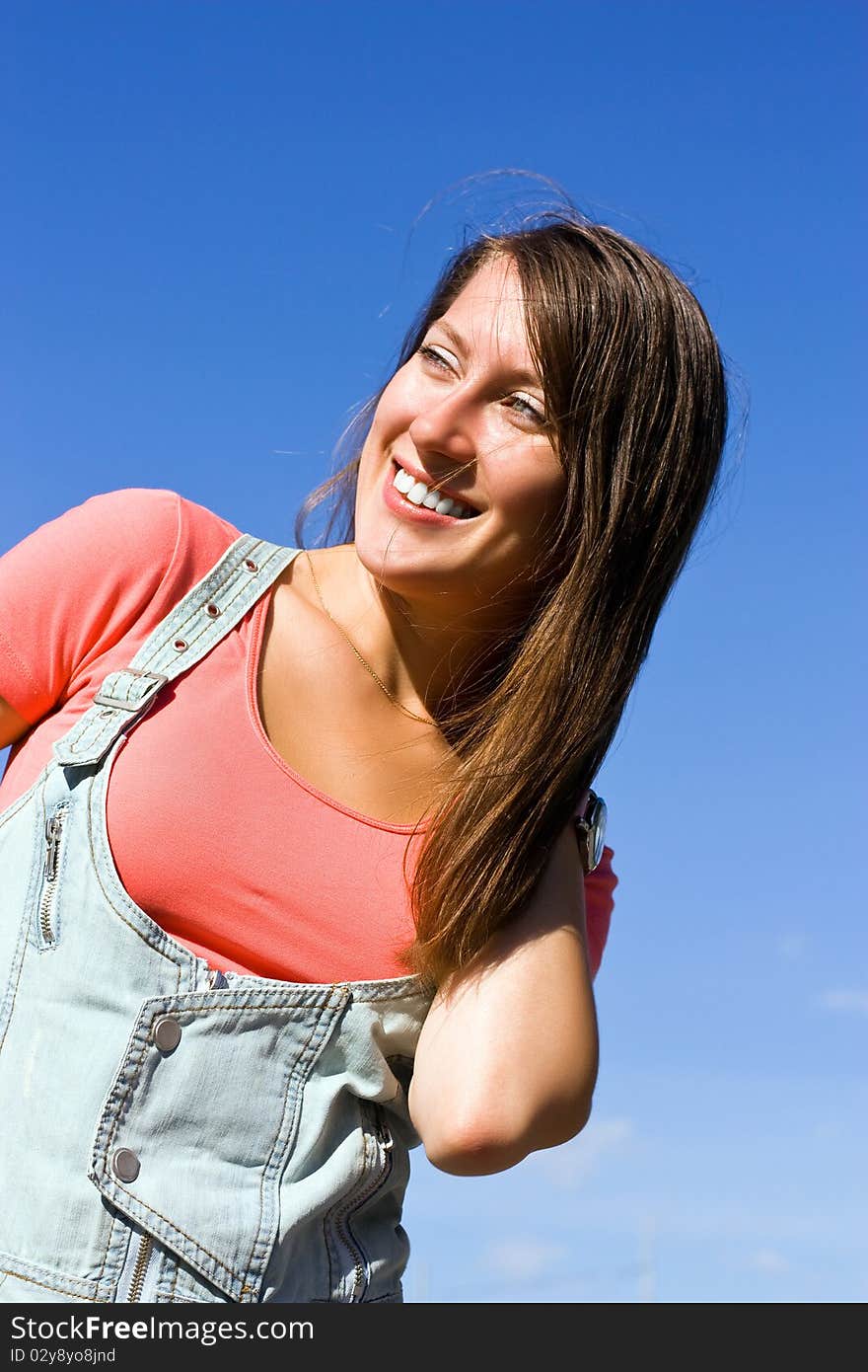 Beautiful young woman under blue sky. Portrait