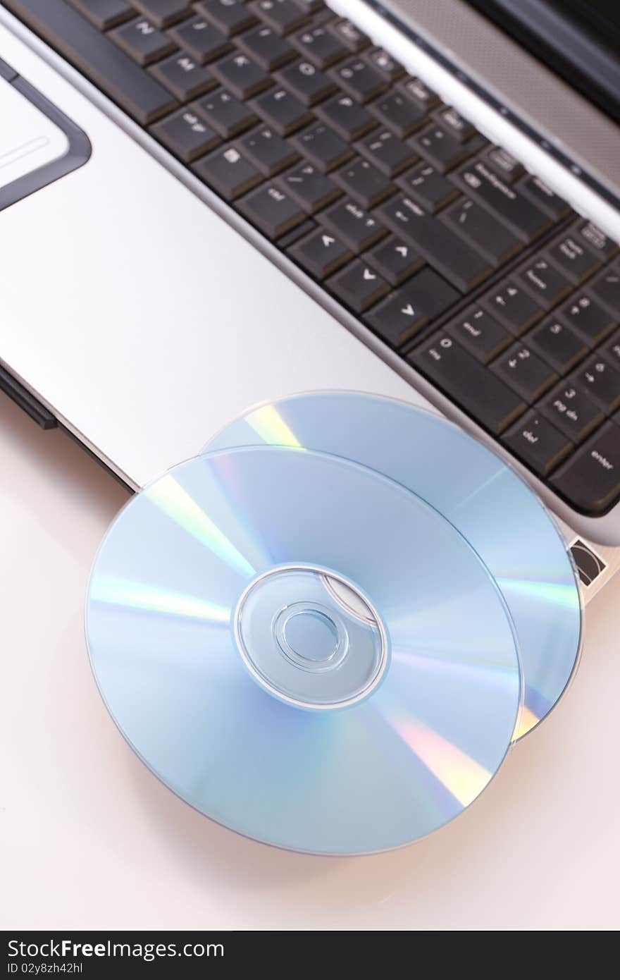 Laptop computer and dvd-s on white background. Laptop computer and dvd-s on white background