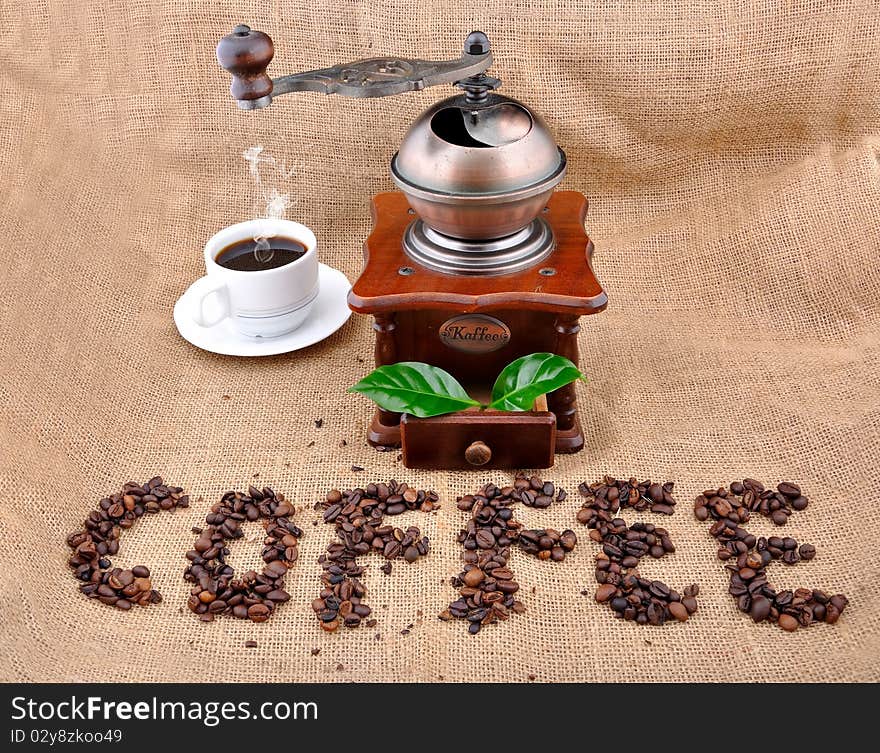 Vintage coffee grinder and sign coffe from coffee granules with coffee plant