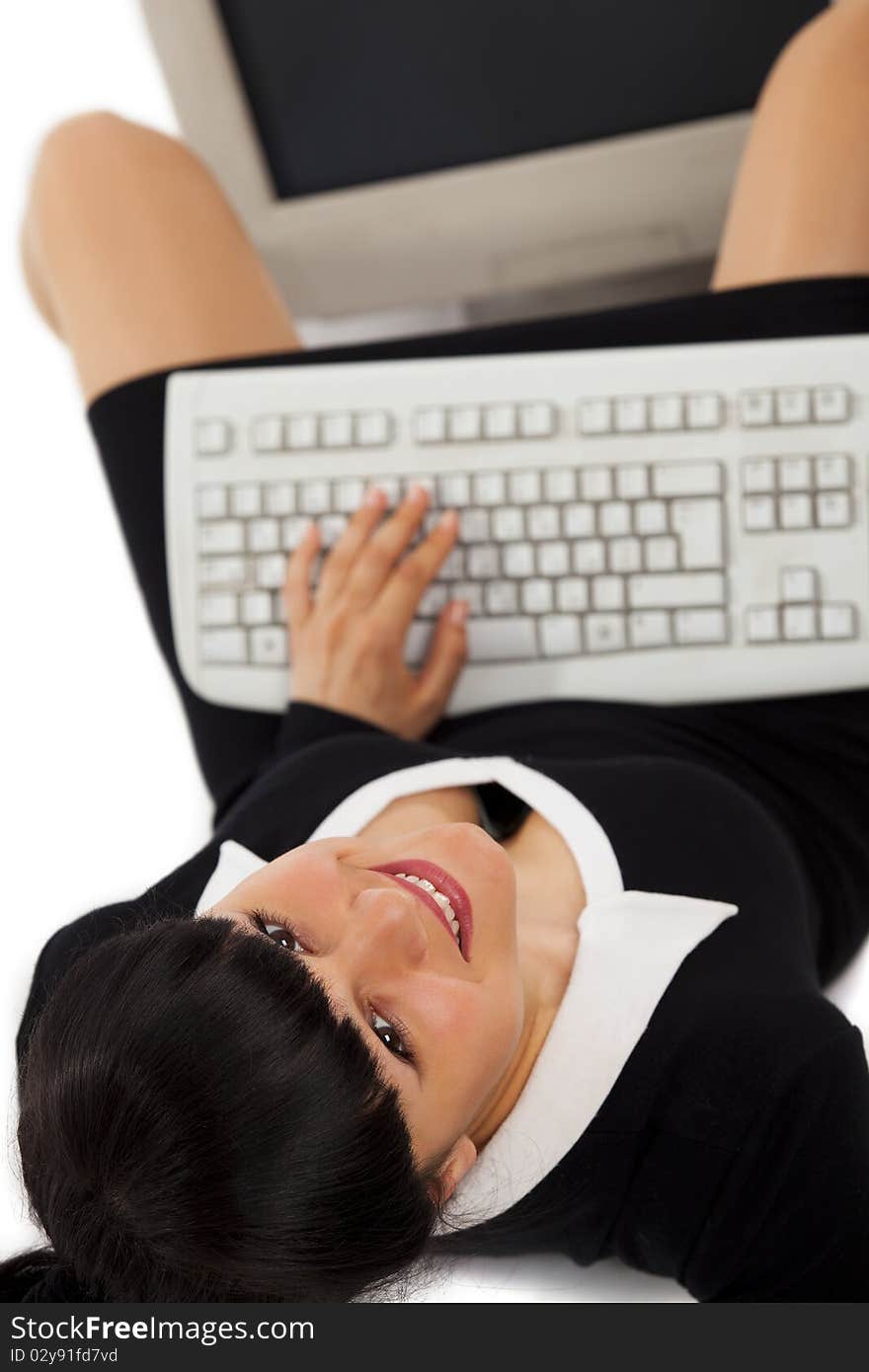 Smiling business woman with a keyboard looking at the camera. Top view