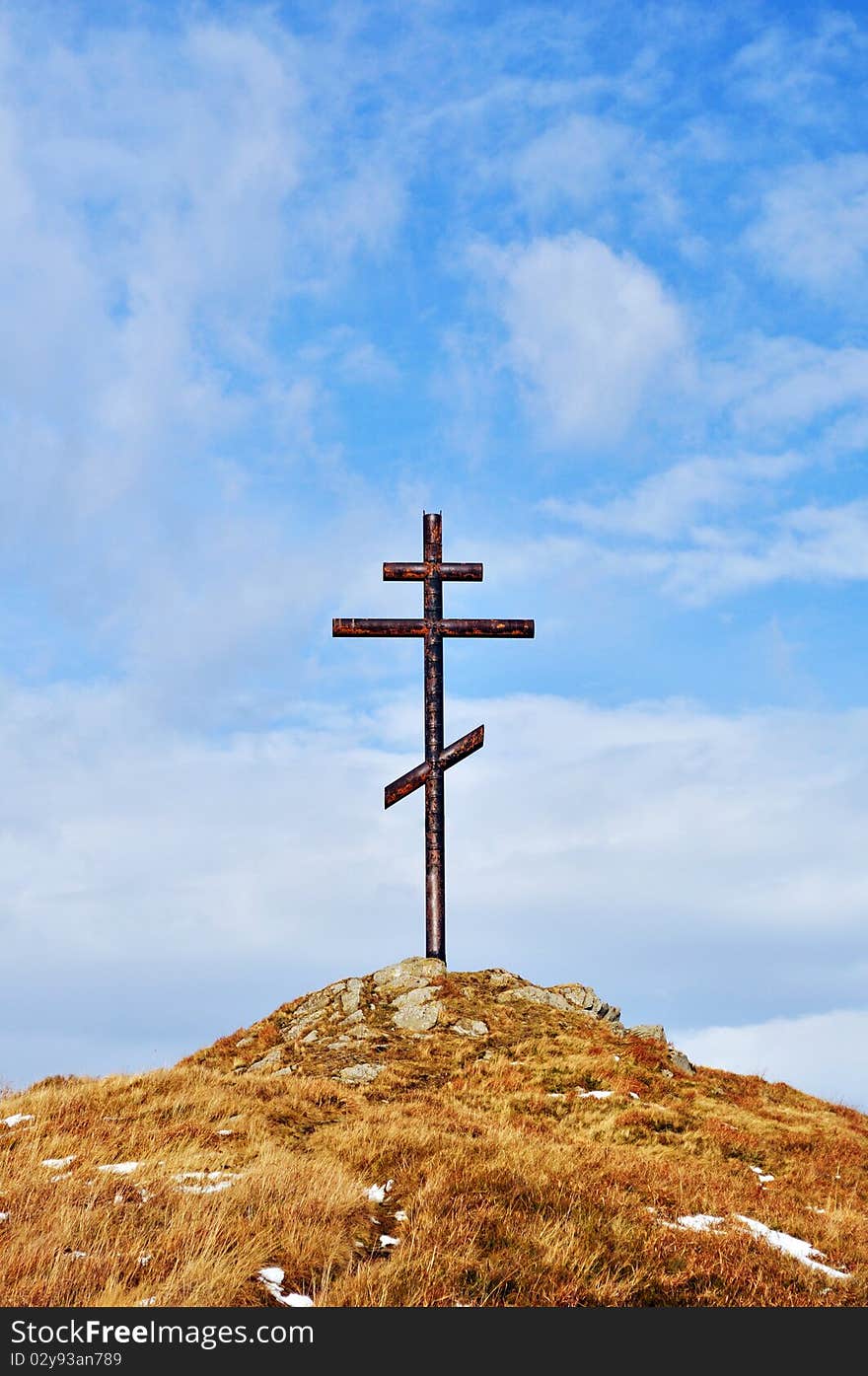 Cross against the sky on high hill