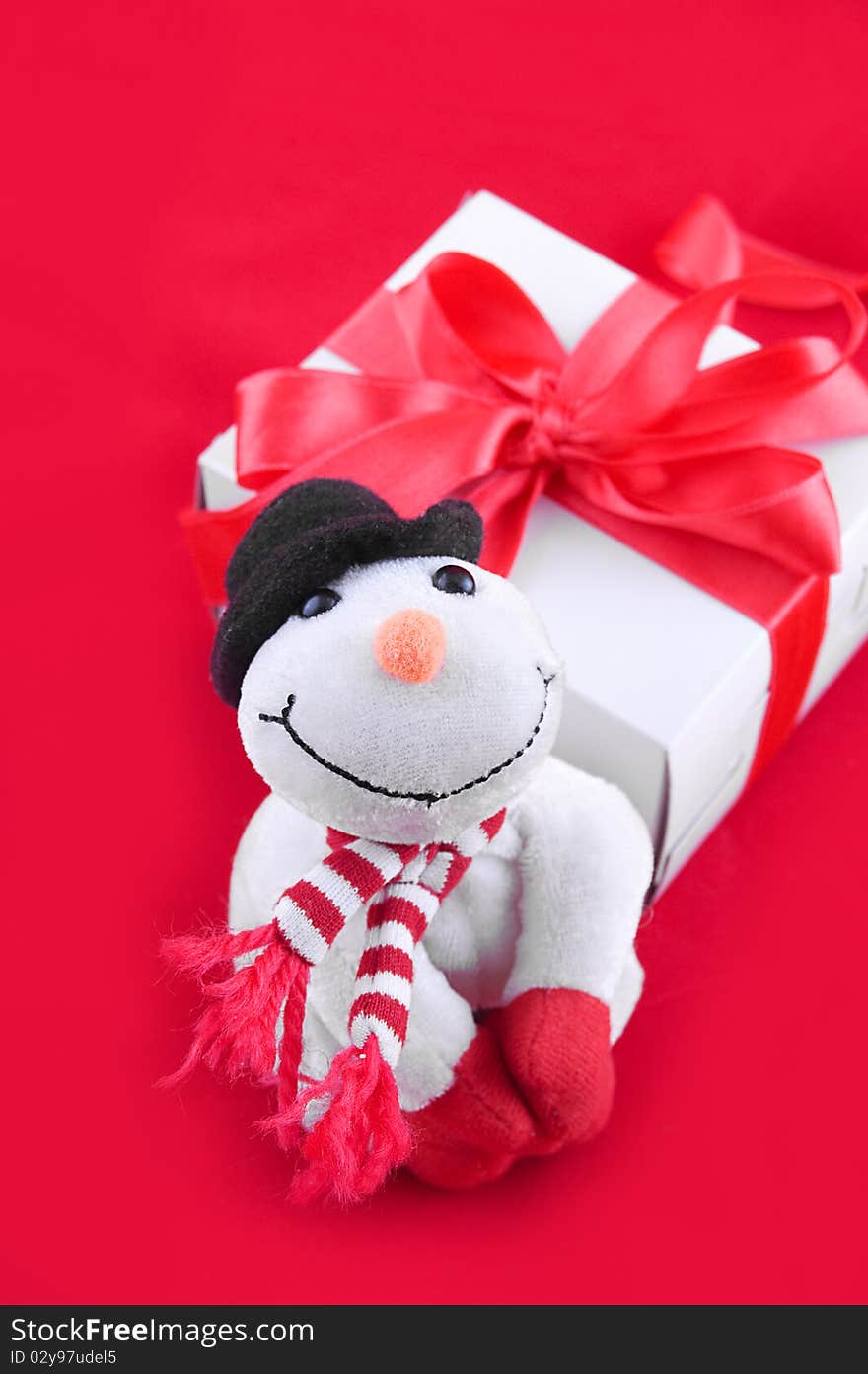 Snowman and giftbox on red background