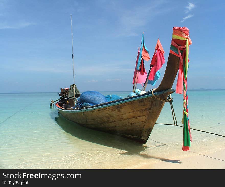 A boat that used for fishing stay on the white beach on sunny day.
. A boat that used for fishing stay on the white beach on sunny day.