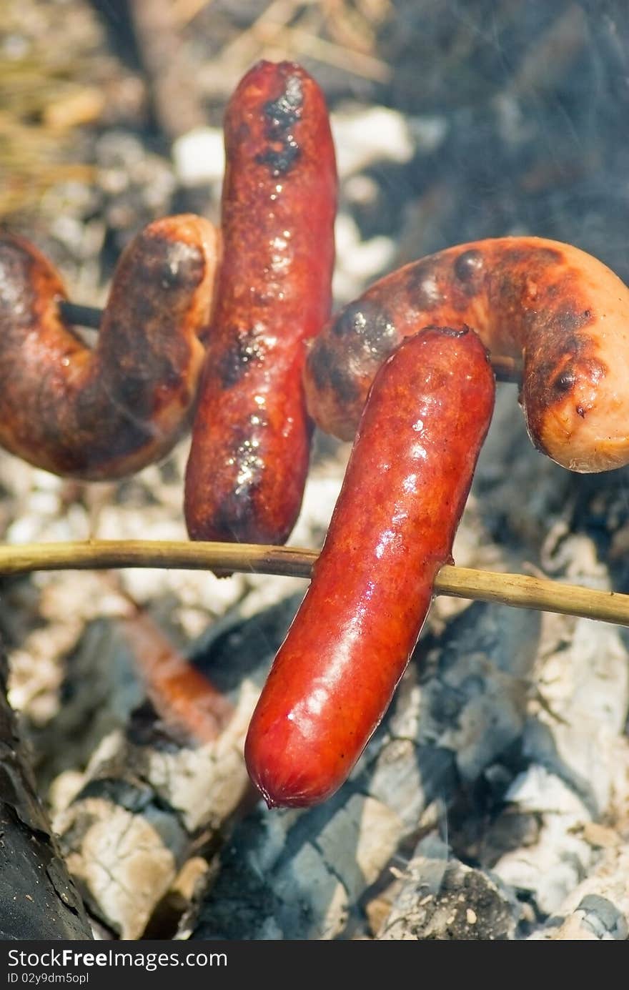 Cooking of sausages on the hot embers