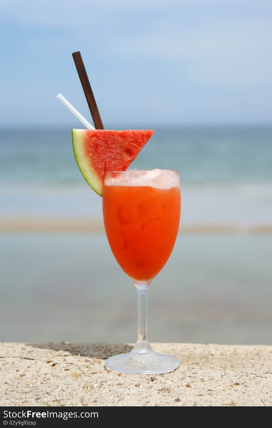 Refreshing red cocktail beverage on the beach