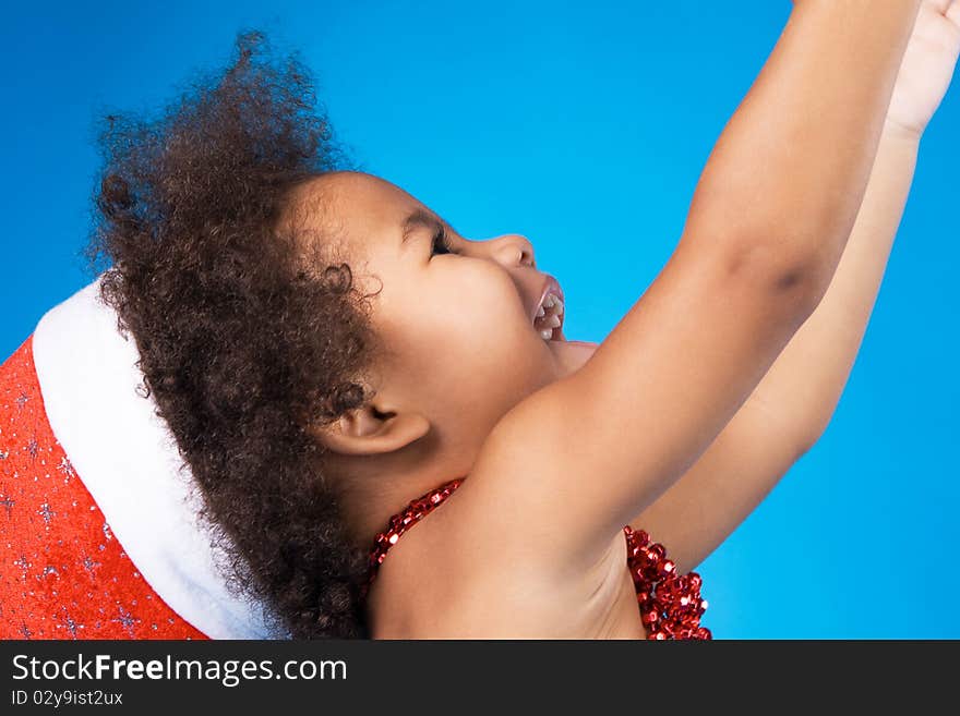 Cheerful little baby in Christmas hat having fun