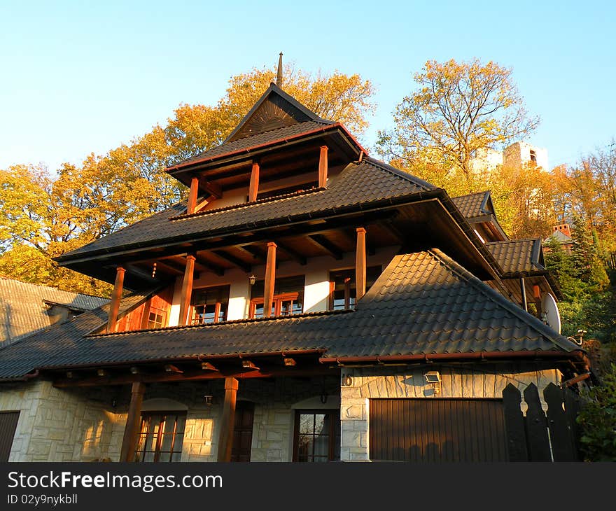 Modern wooden house with autumn tree