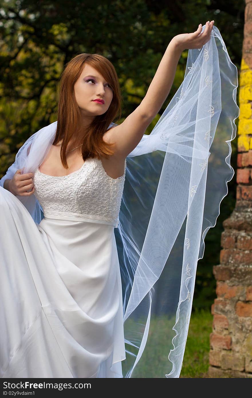 Young beautiful woman posing in a white dress in the nature. Young beautiful woman posing in a white dress in the nature