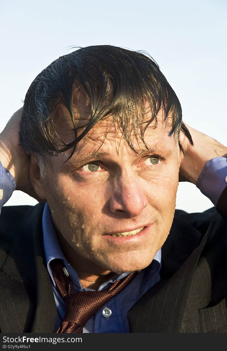 A portrait of a depressed and soaking wet businessman wearing a suit and tie. A portrait of a depressed and soaking wet businessman wearing a suit and tie