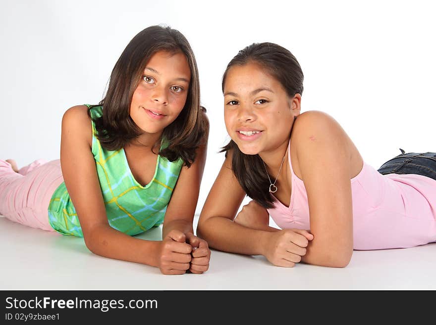 Studio shot of two teenage girls relaxing on the studio floor - Canon 5D MKII. Studio shot of two teenage girls relaxing on the studio floor - Canon 5D MKII