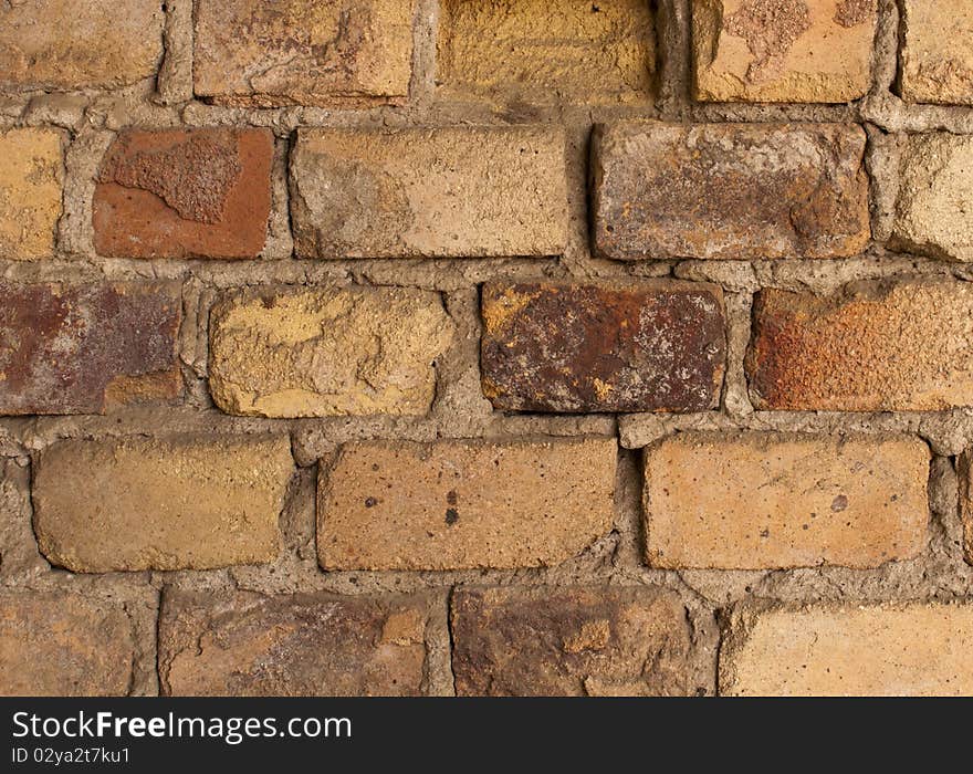 The old brick wall with crumbling plaster