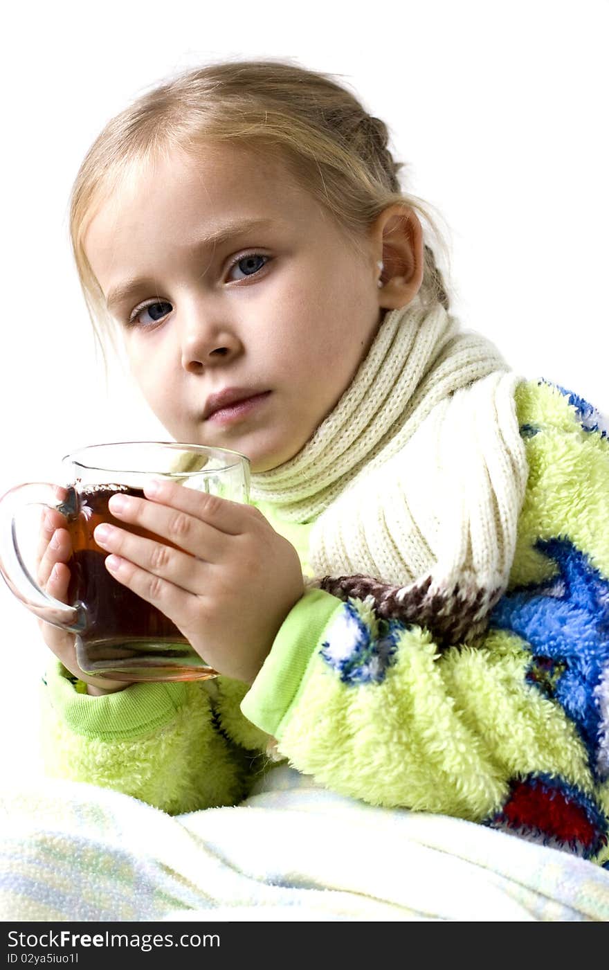 Child in scarf is ill with cup of tea. Child in scarf is ill with cup of tea