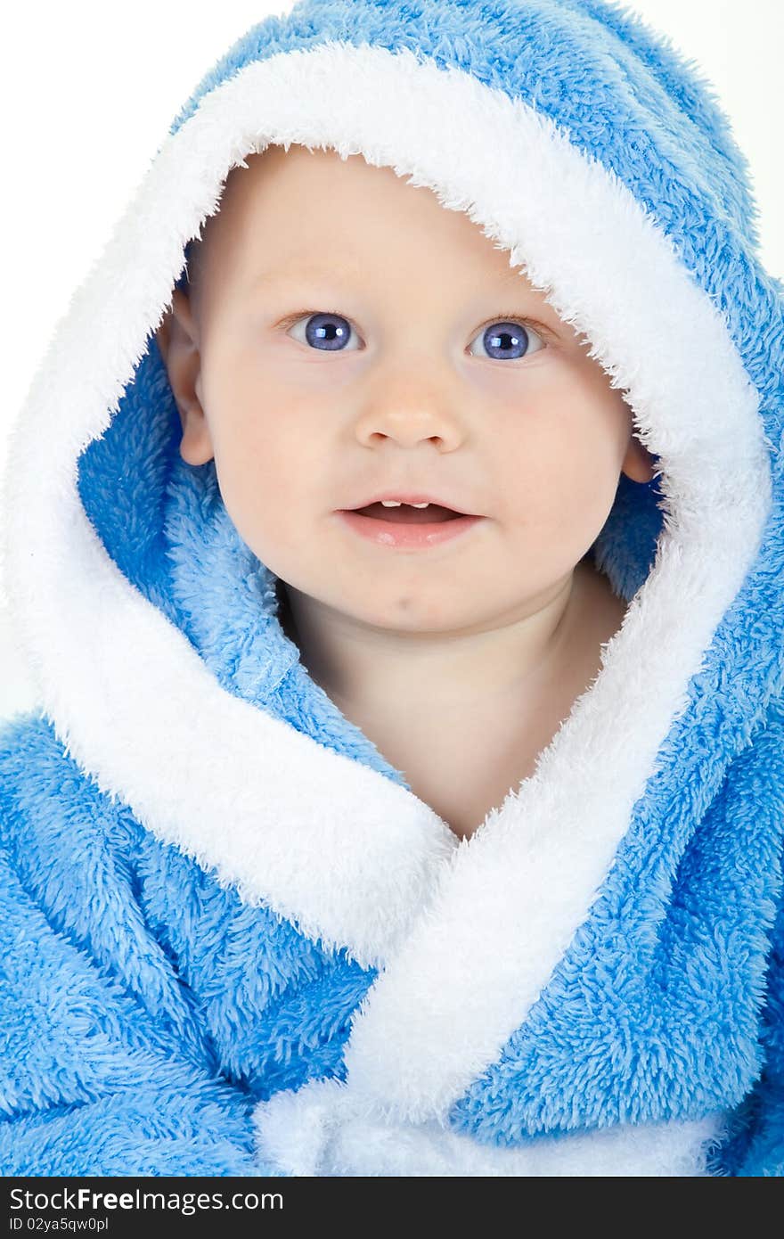 Charming baby with blue eyes in a blue fluffy bathrobe. Charming baby with blue eyes in a blue fluffy bathrobe