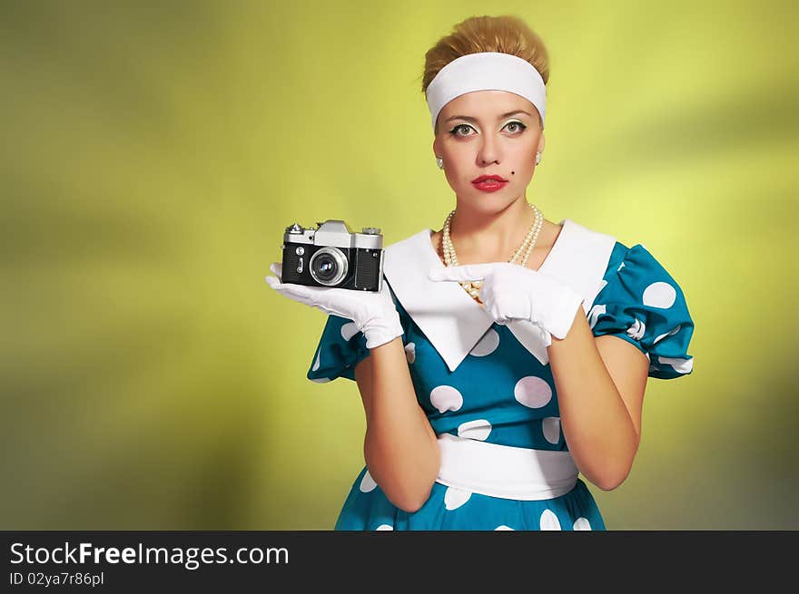 Beautiful young lady with a camera in retro style