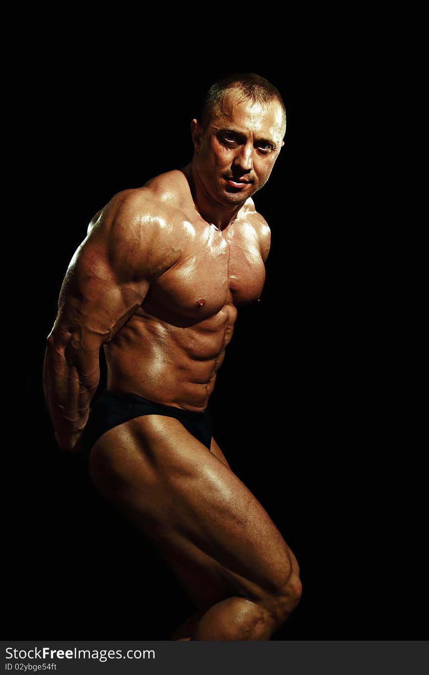 Posing man bodybuilder on a black background. Posing man bodybuilder on a black background