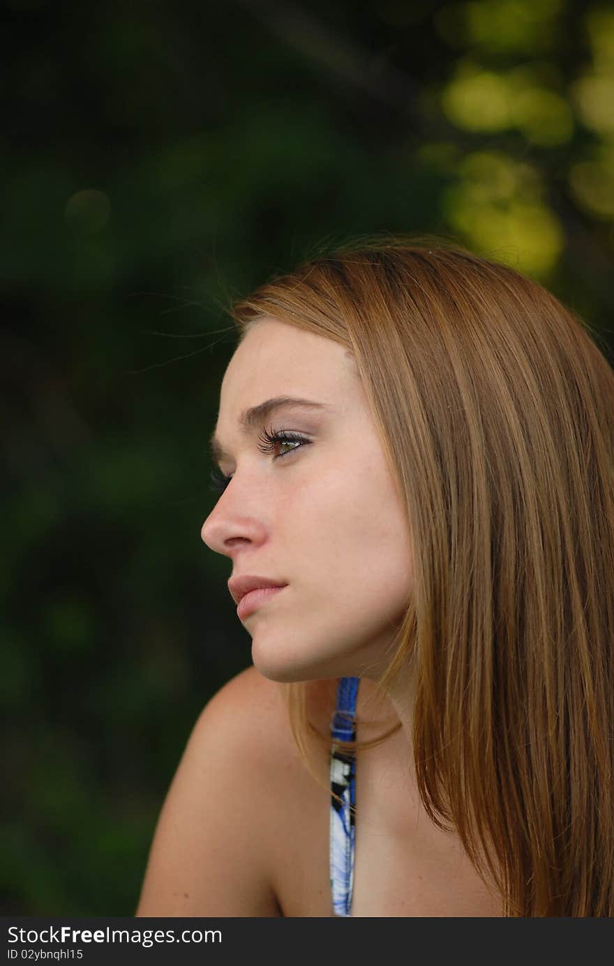 A portrait of a lovely young woman shot from the side to show her striking features. A portrait of a lovely young woman shot from the side to show her striking features.