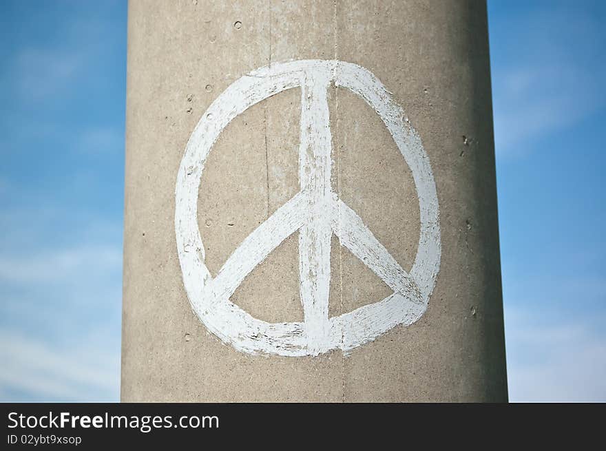 Peace Sign on a Concrete Pillar with Blue Sky